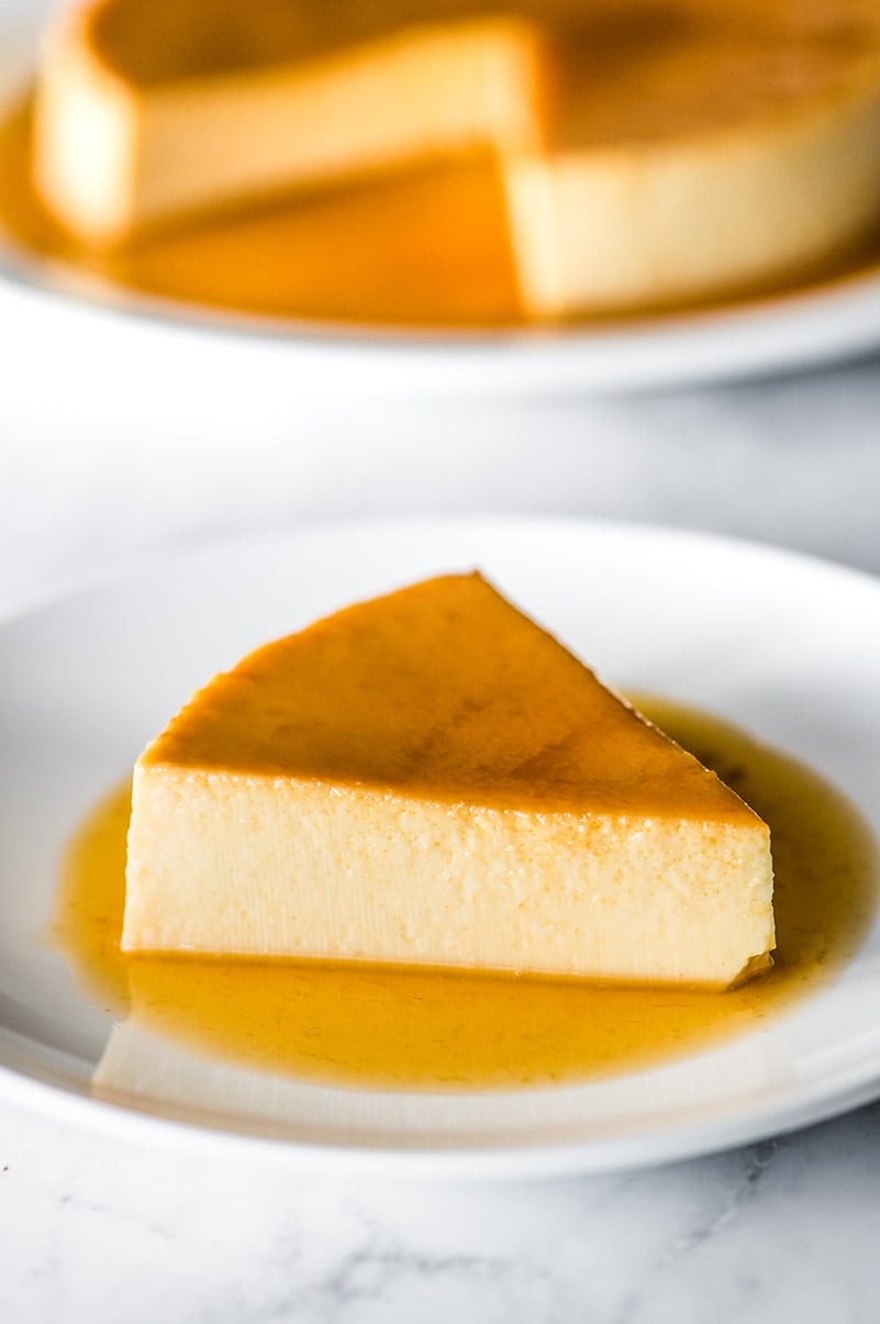 A slice of flan on a plate with caramel