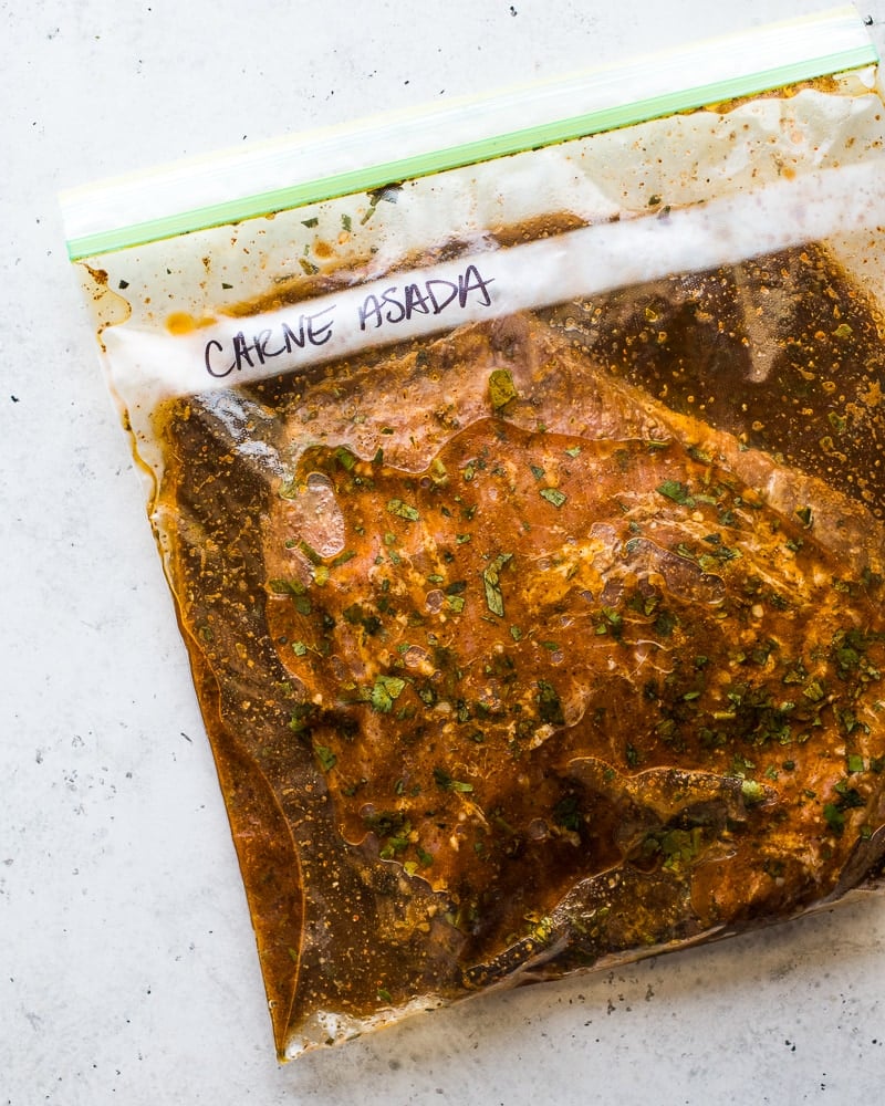 Carne asada marinating in a zip top plastic bag.