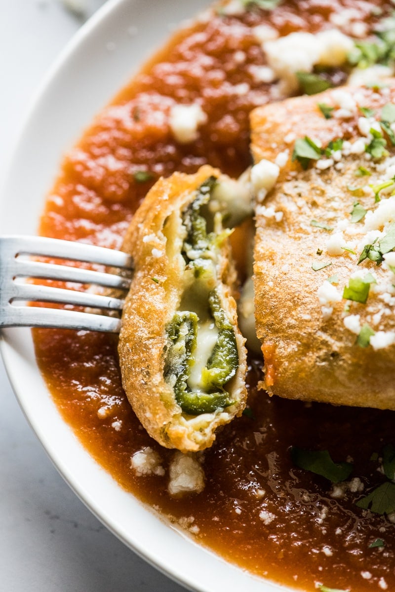 A chile relleno sliced open showing melted cheese.