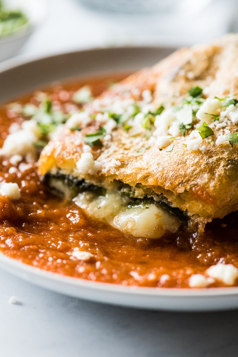 Melted cheese oozing out of a chile relleno on a plate.