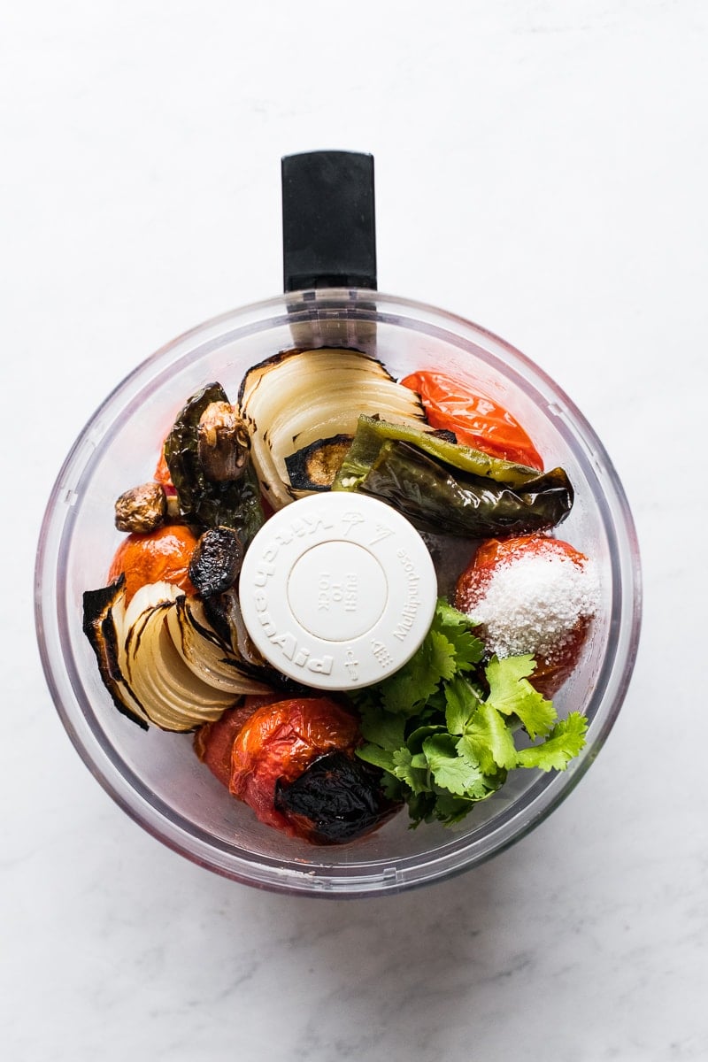 Roasted tomato salsa ingredients in a food processor.