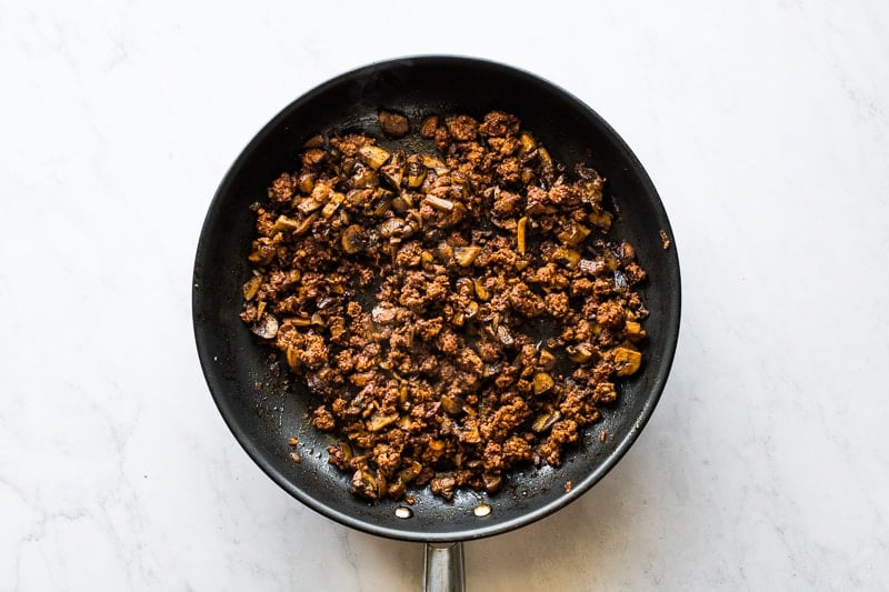 Cooked chorizo and mushrooms in a skillet