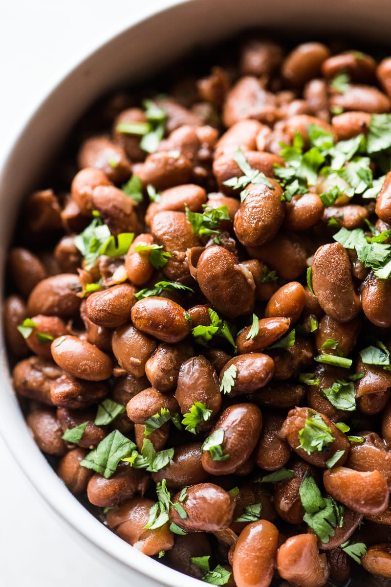 Tender instant pot pinto beans topped with cilantro.