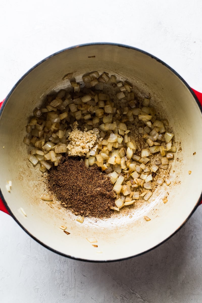 Onions, garlic and seasoning in a pot for pinto bean soup.