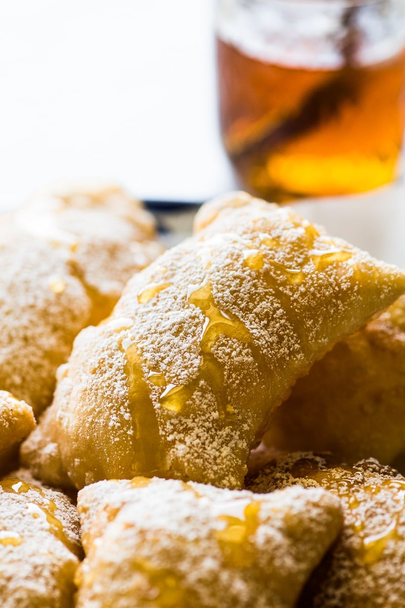 Sopapillas topped with powdered sugar and honey.