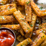 Crispy baked jicama fries on a plate with a side of ketchup
