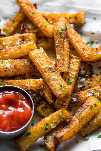 Crispy baked jicama fries on a plate with a side of ketchup