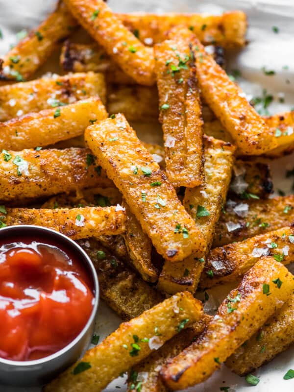 Crispy baked jicama fries on a plate with a side of ketchup