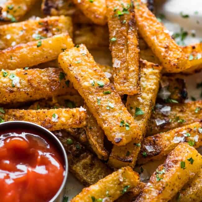 Crispy baked jicama fries on a plate with a side of ketchup