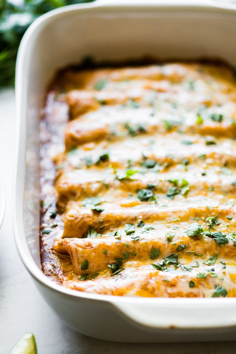 Cheesy chicken enchiladas with melted cheese in a baking dish.