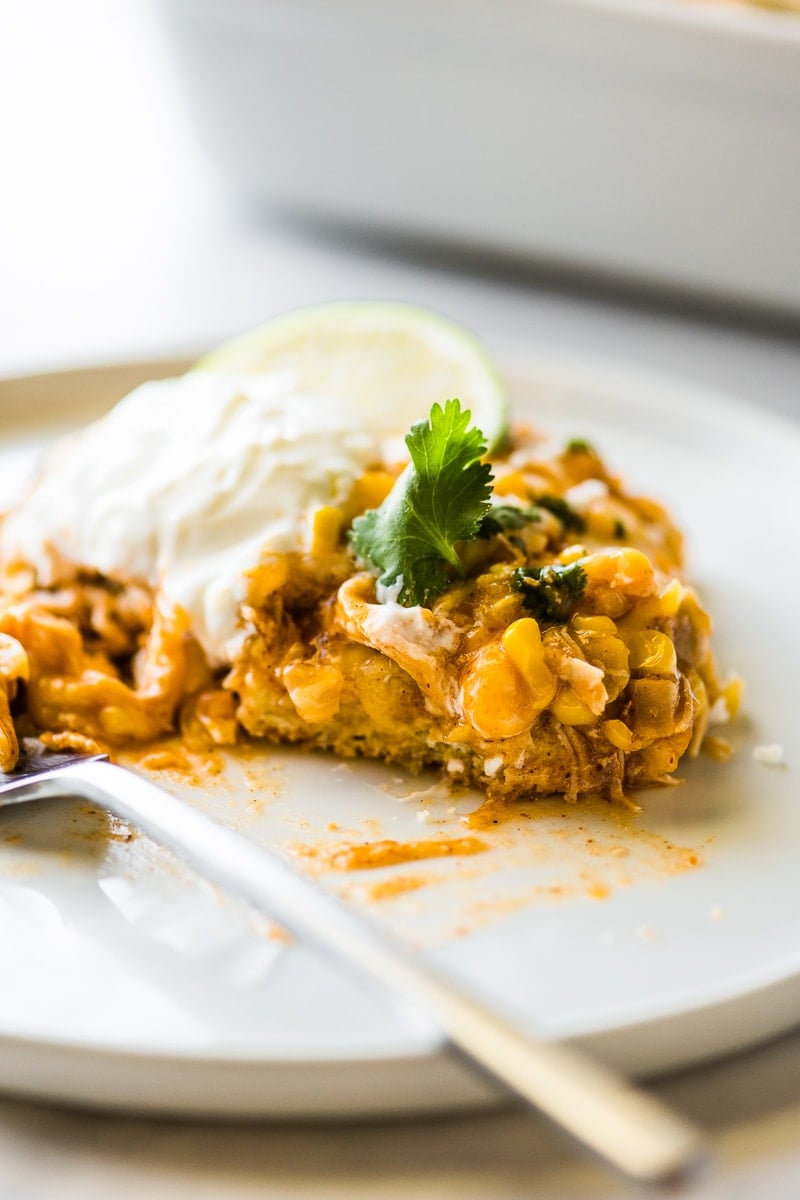 A serving of Chicken Tamale Casserole on a white plate with a fork.