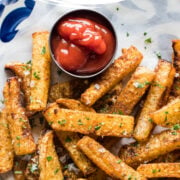 Jicama fries on a plate seasoned with cilantro and salt.