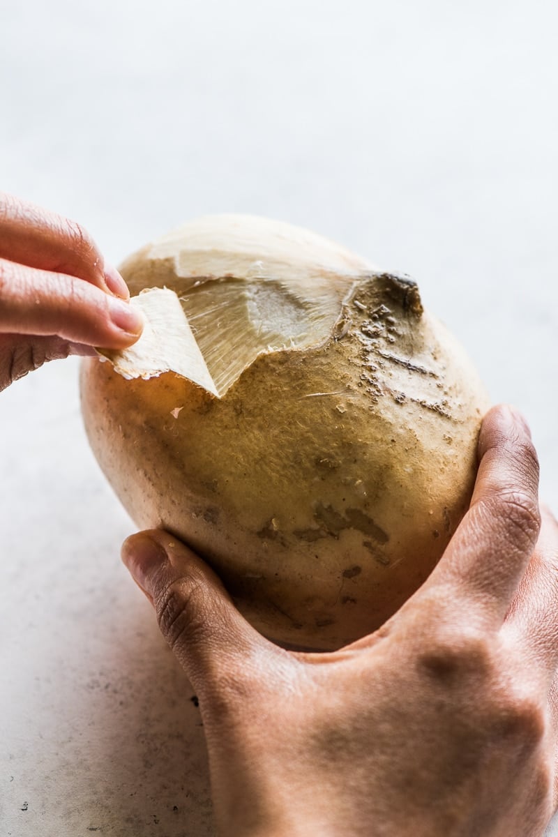 A jicama being peeled