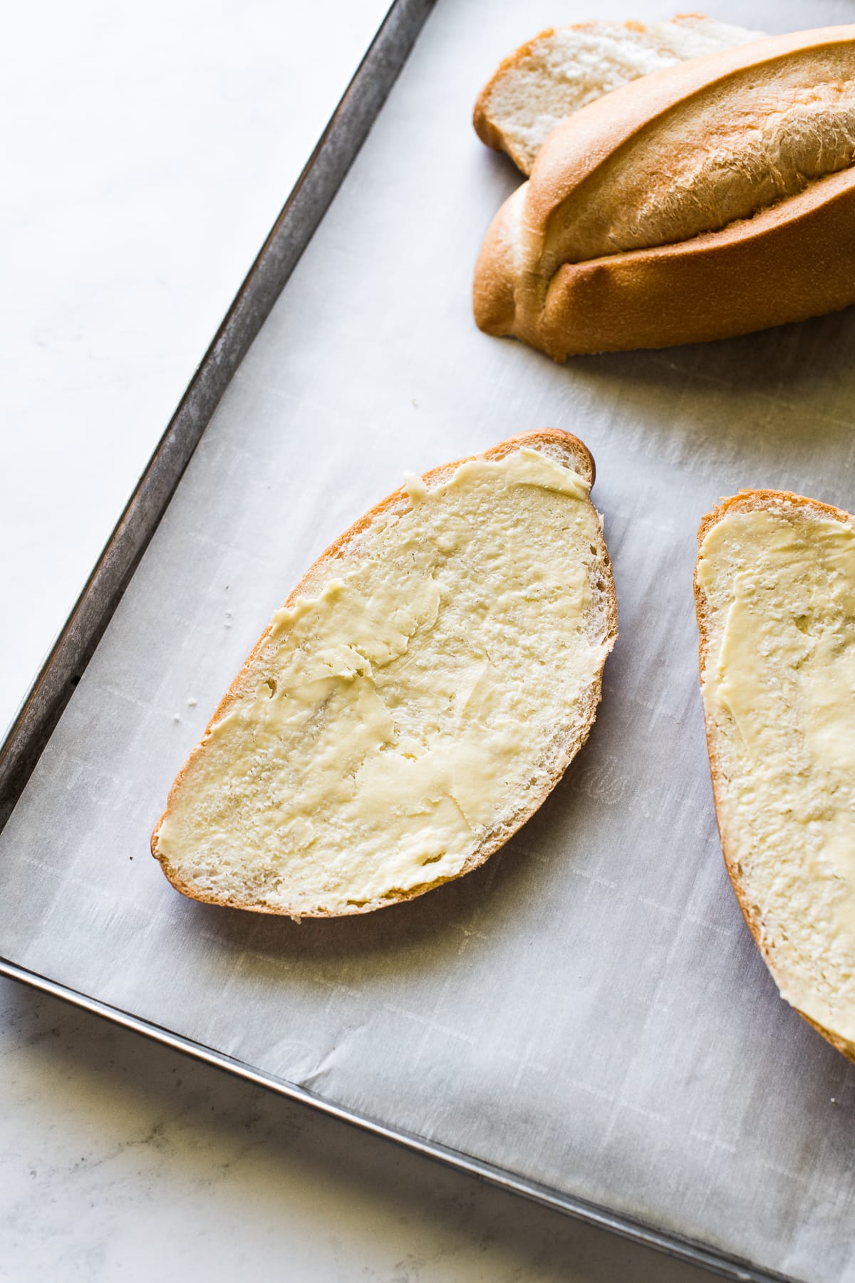 Butter smeared on Mexican bolillo bread