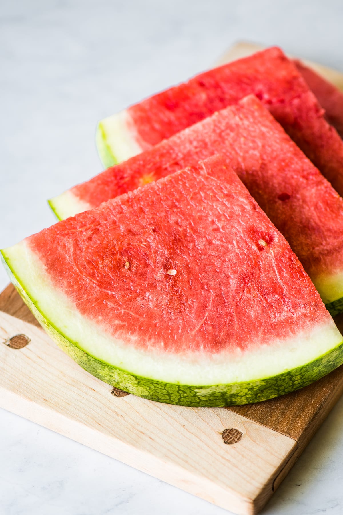 Slices of fresh watermelon on a cutting board.