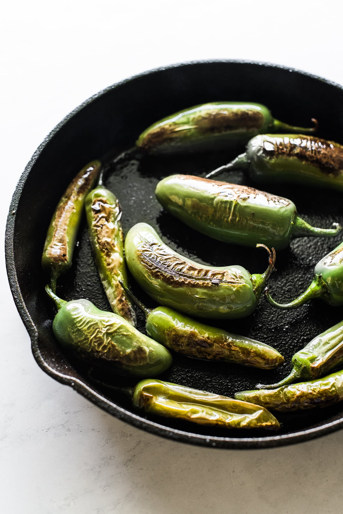 Jalapeno peppers in a skillet to make chiles torreados