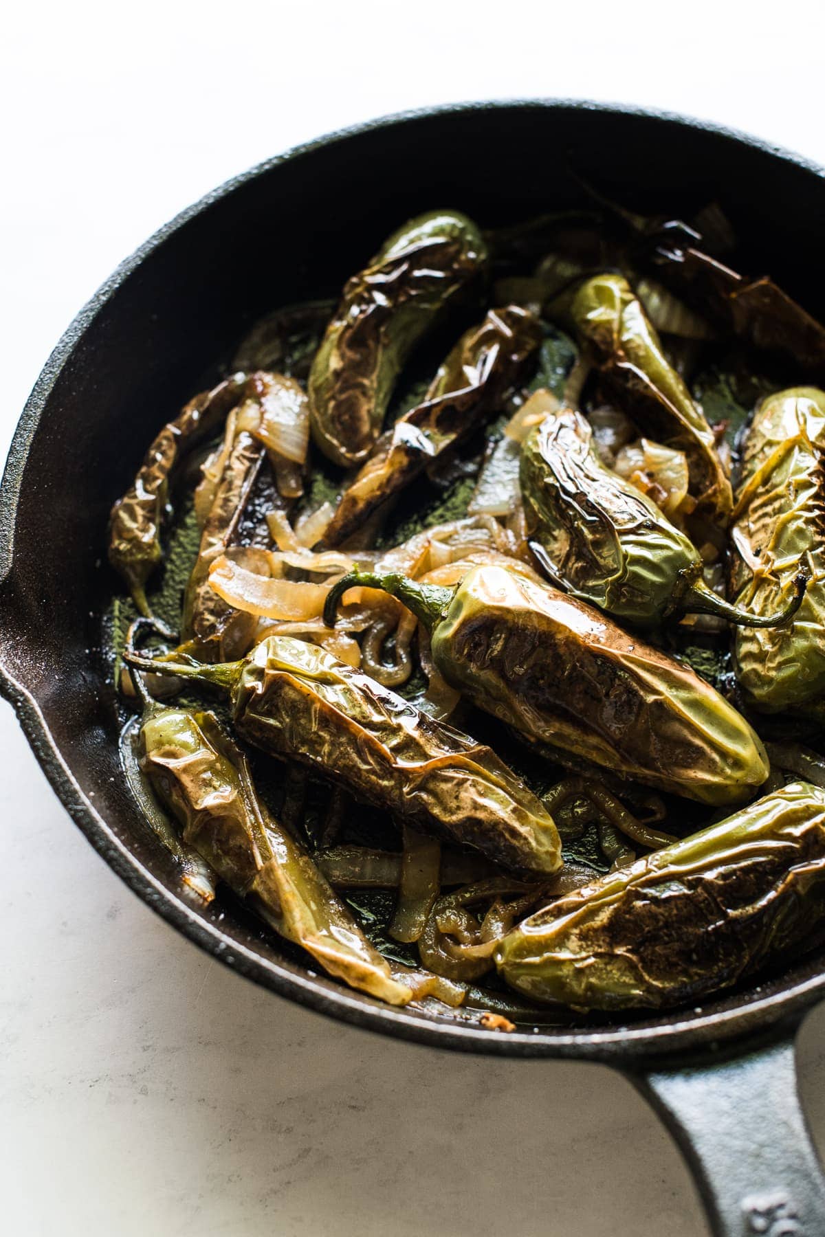 Chiles toreados in a skillet.