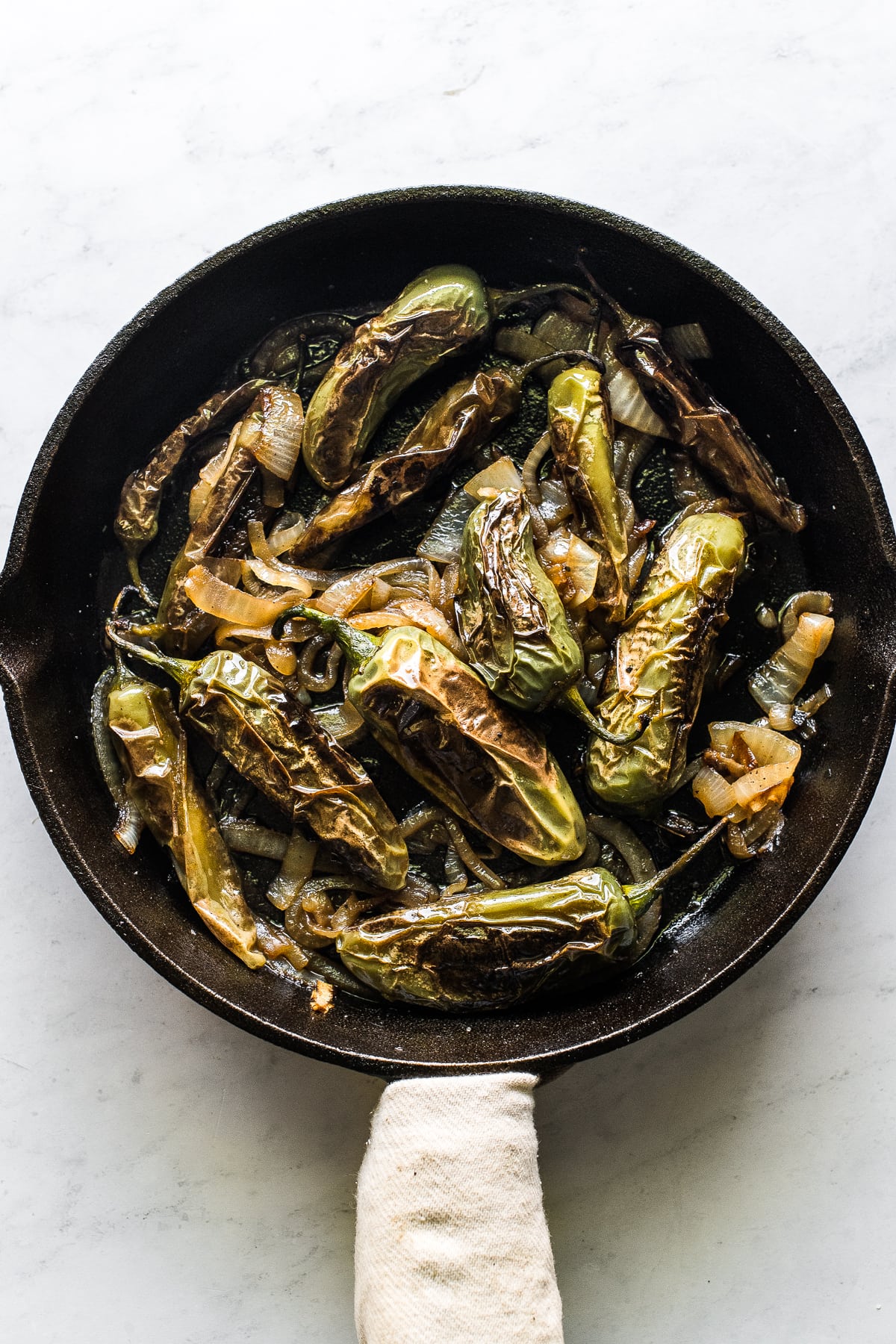 Chiles toreados in a cast iron skillet.