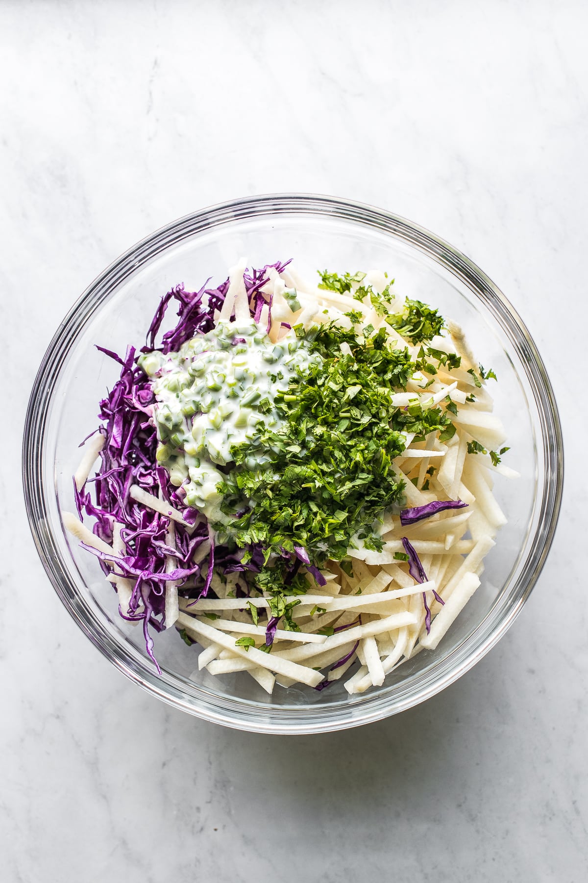 Jicama slaw ingredients in a bowl getting ready to be tossed together.