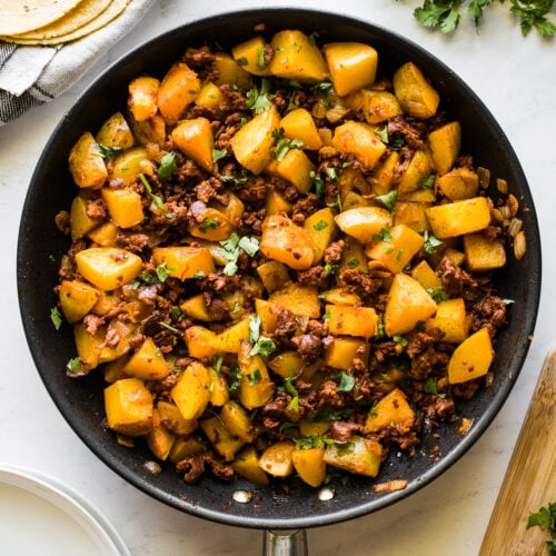 Papas con chorizo (or potatoes with chorizo) in a large skillet.