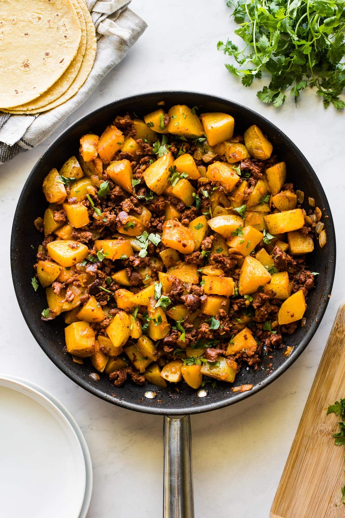 Papas con chorizo (or potatoes with chorizo) in a large skillet.