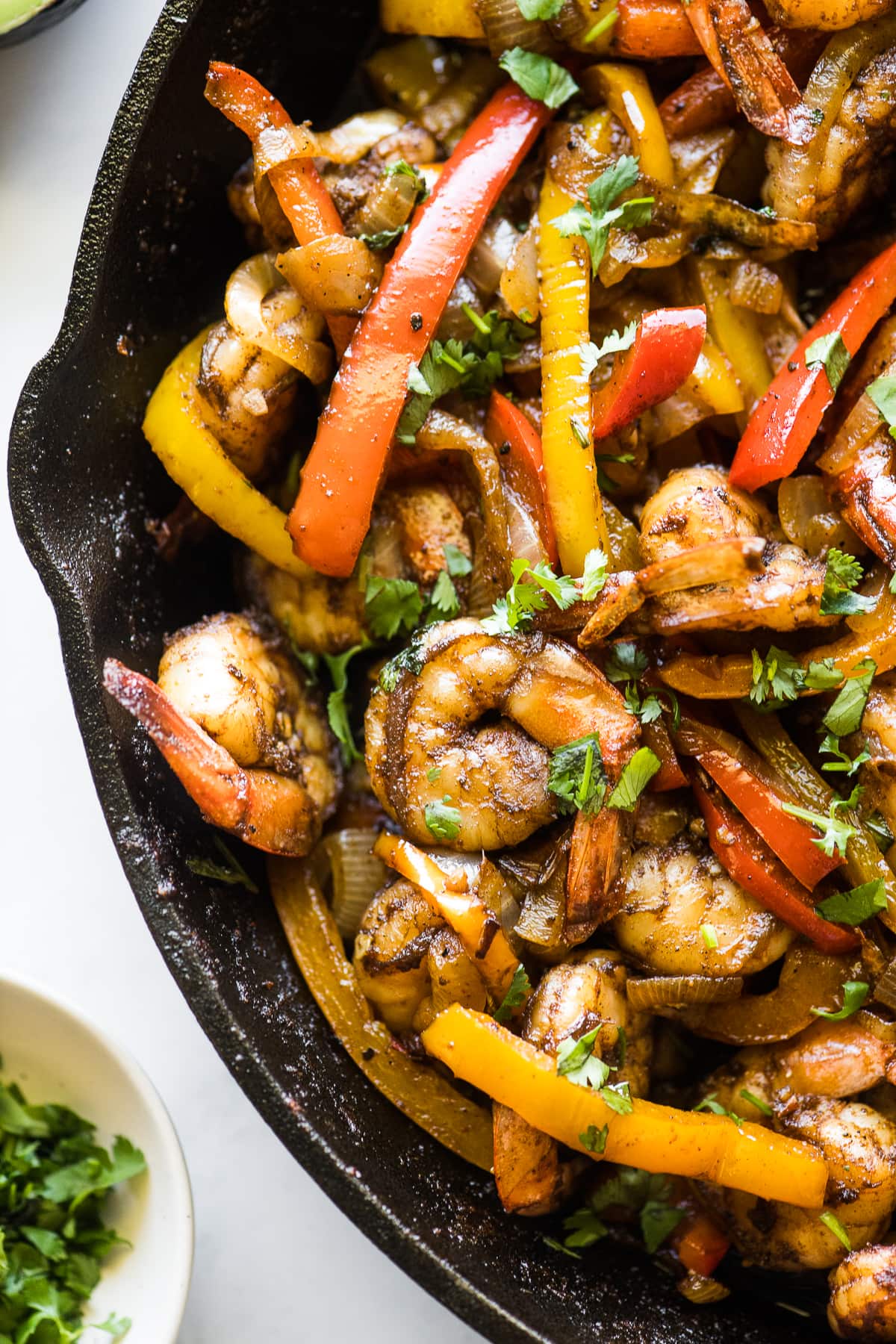 Shrimp fajitas with bell peppers in a skillet.