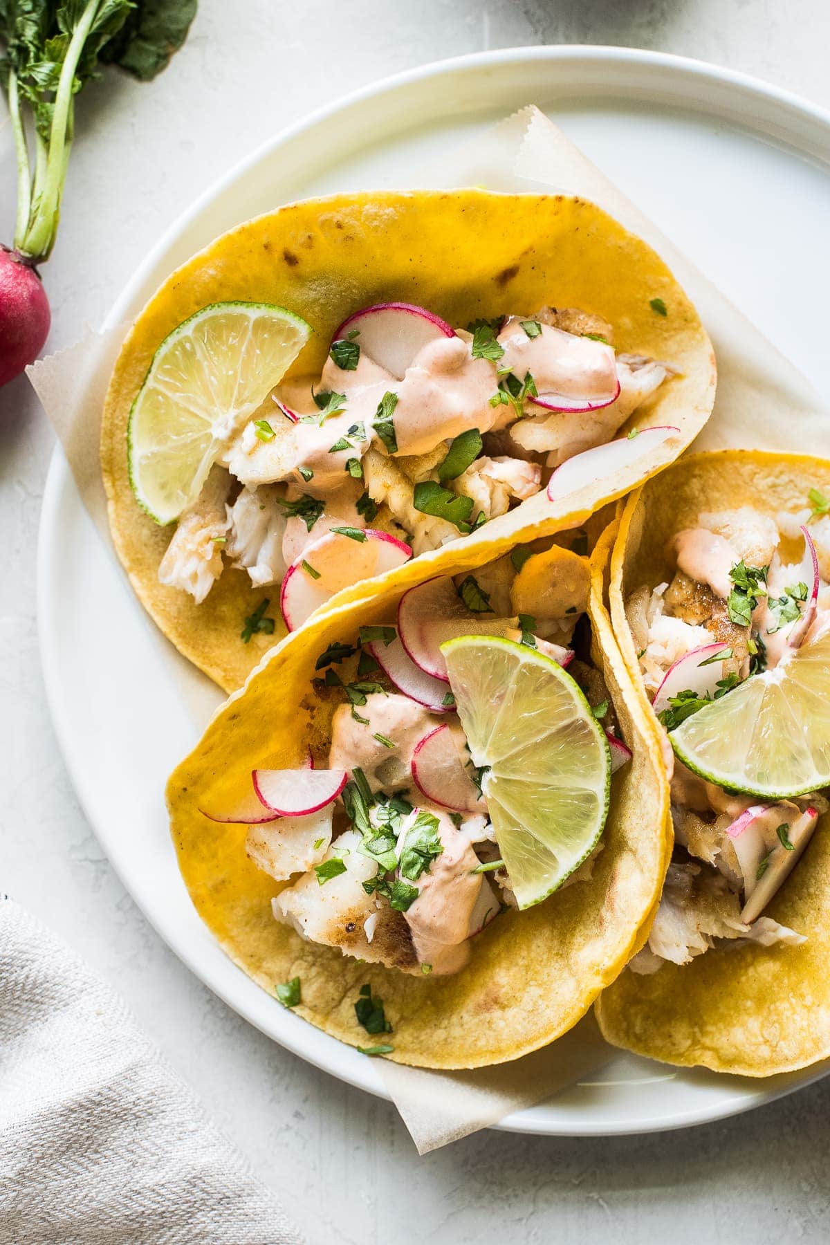 Tilapia fish tacos topped with cilantro and chipotle lime crema.