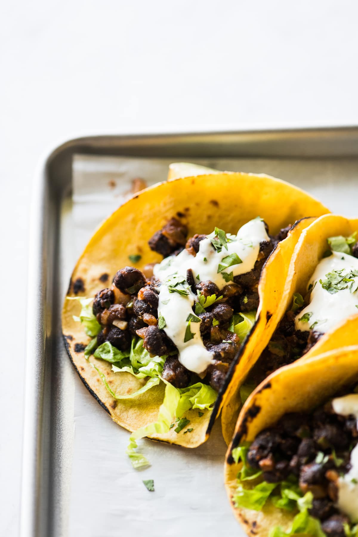 Black bean tacos topped with sour cream.