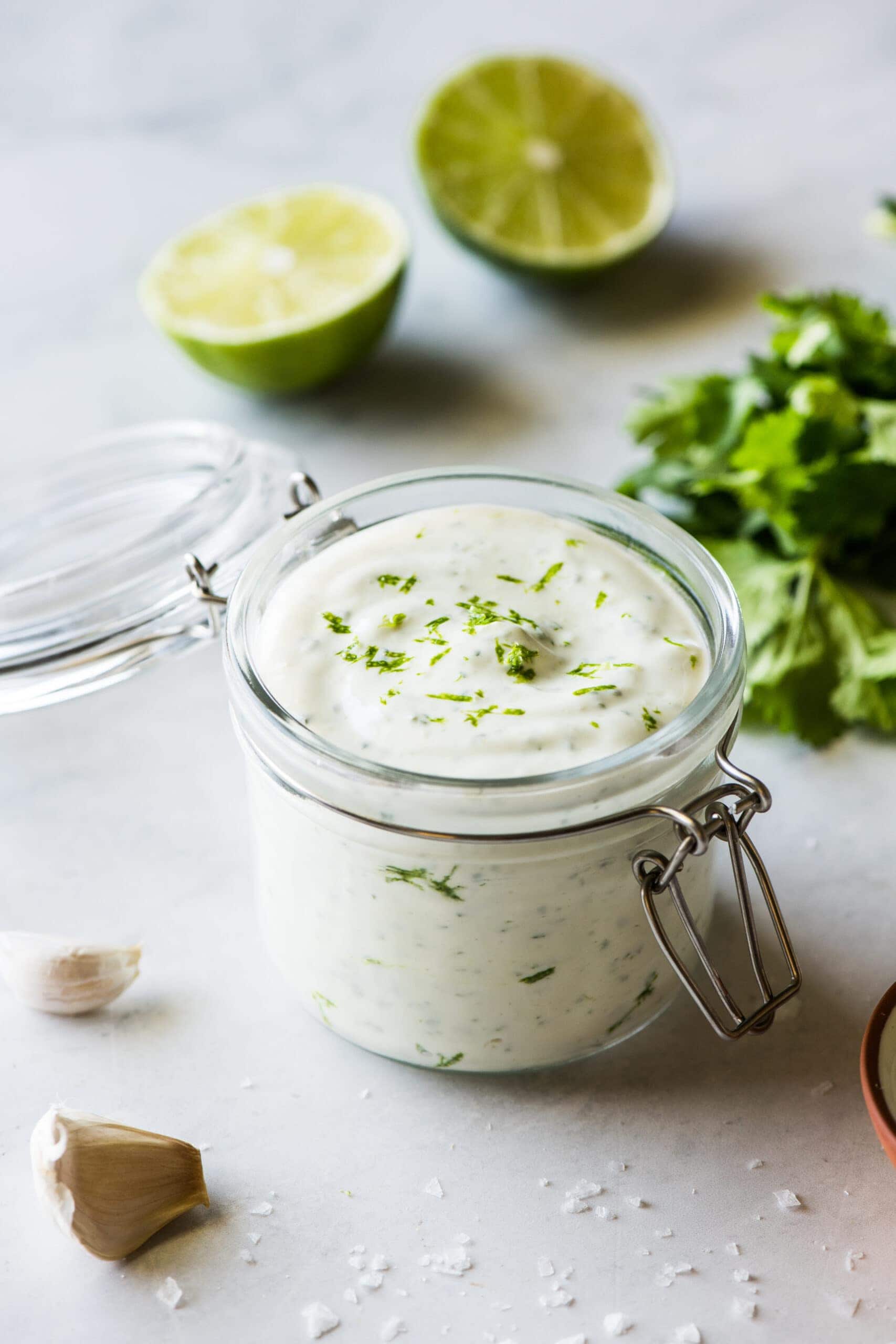 Cilantro lime crema in a jar topped with chopped cilantro.