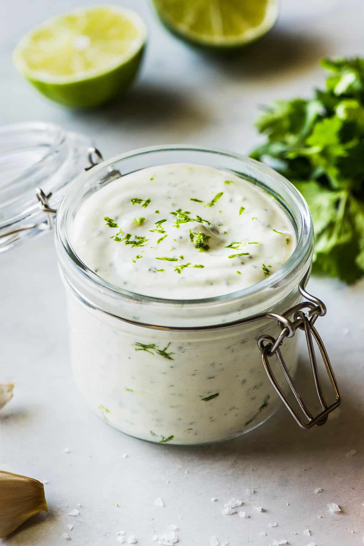 Cilantro lime crema in a jar topped with chopped cilantro.