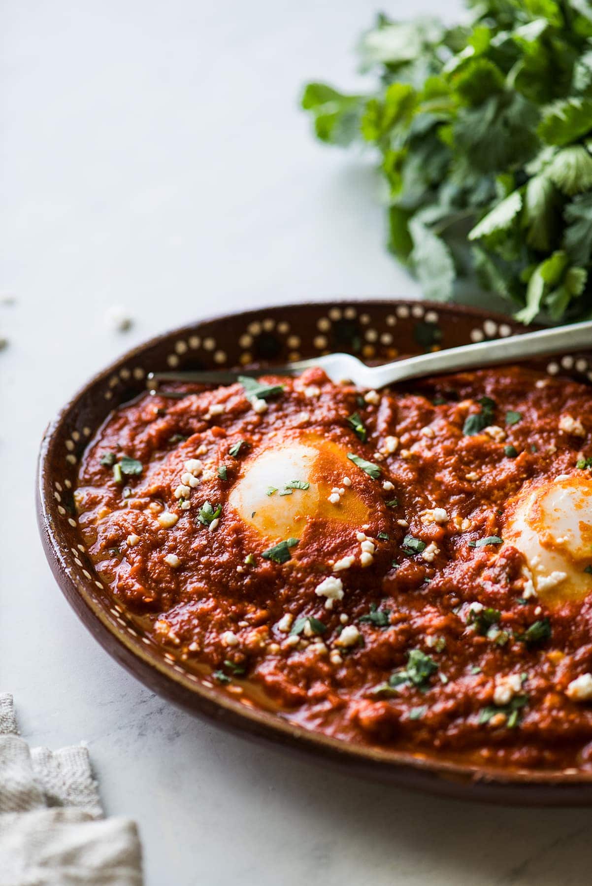 Huevos ahogados in a red salsa.