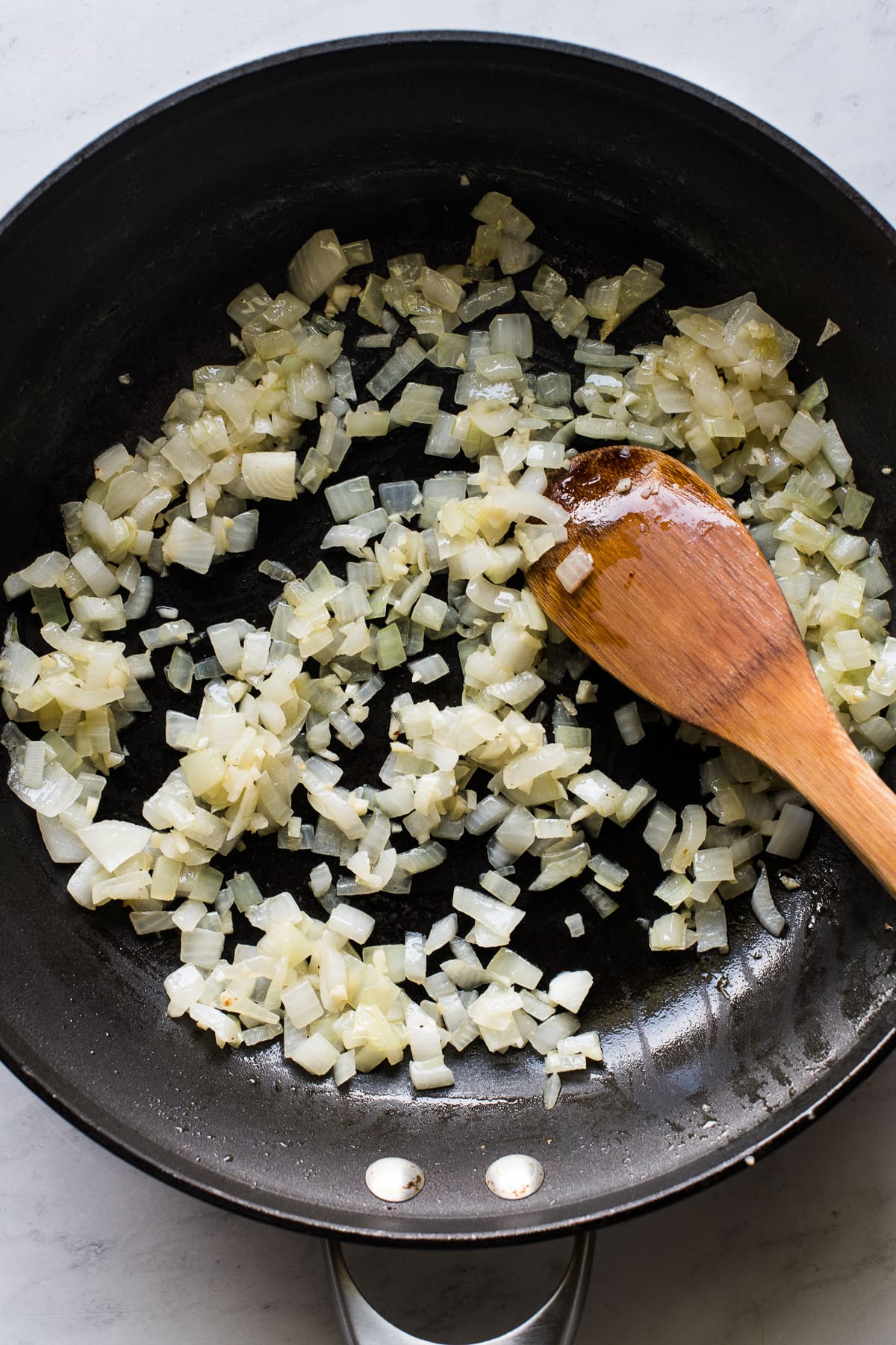 Onion and garlic sauteeing in a skillet.