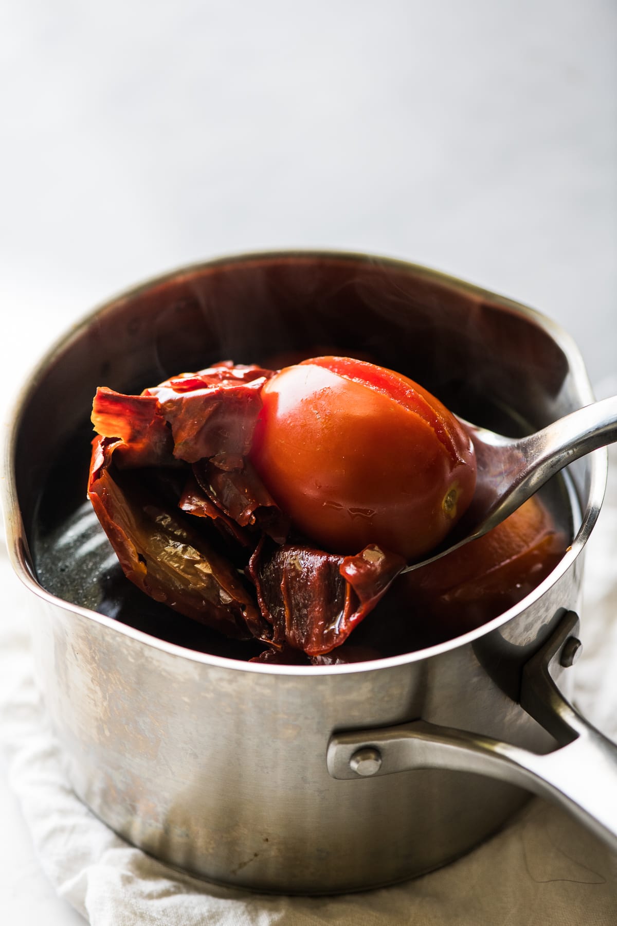 Tomatoes and rehydrated chiles in a pot.