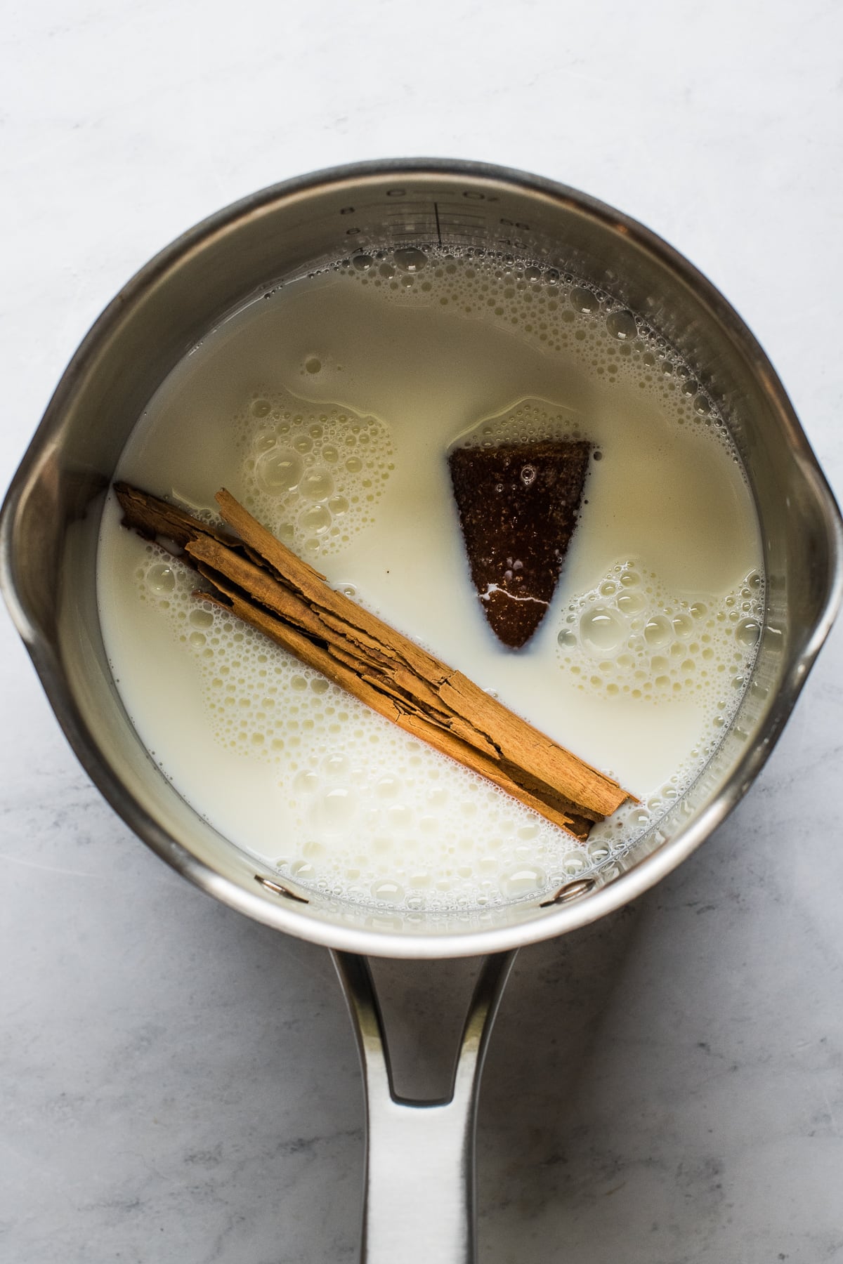 Milk, piloncillo, and cinnamon in a small pot.