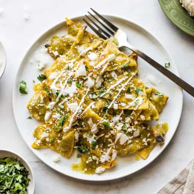 Chilaquiles verdes en plato blanco.