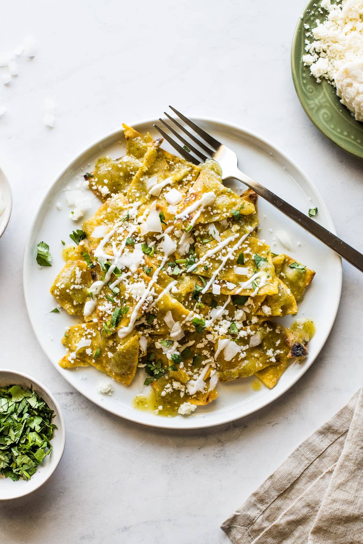 Chilaquiles verdes on a white plate.