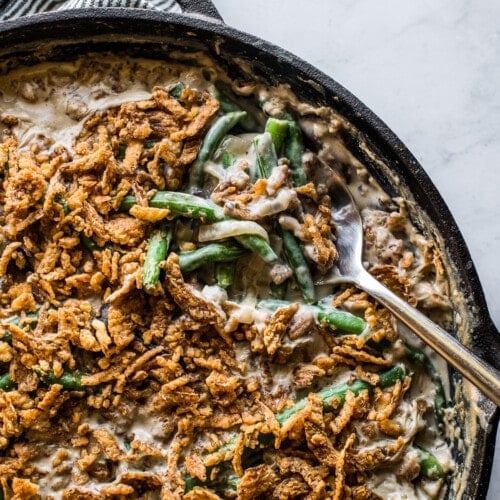 A spoon grabbing a portion of green bean casserole to serve.