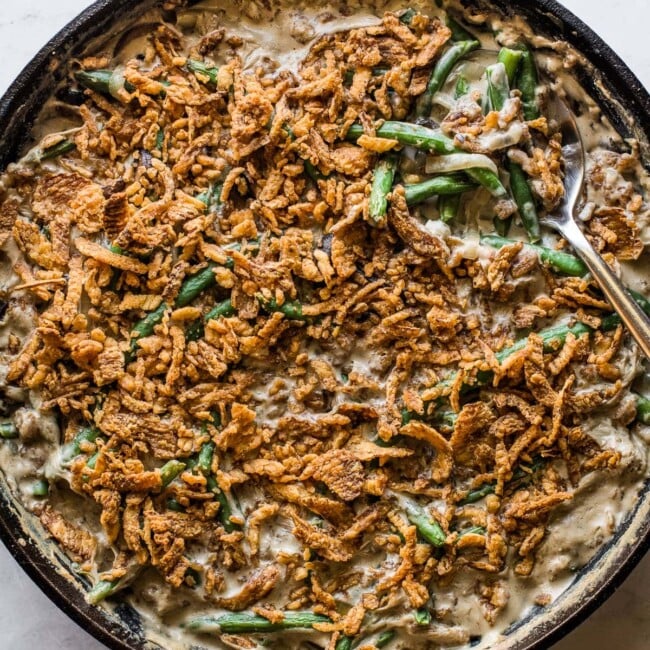 Green bean casserole recipe in a large skillet ready to serve.