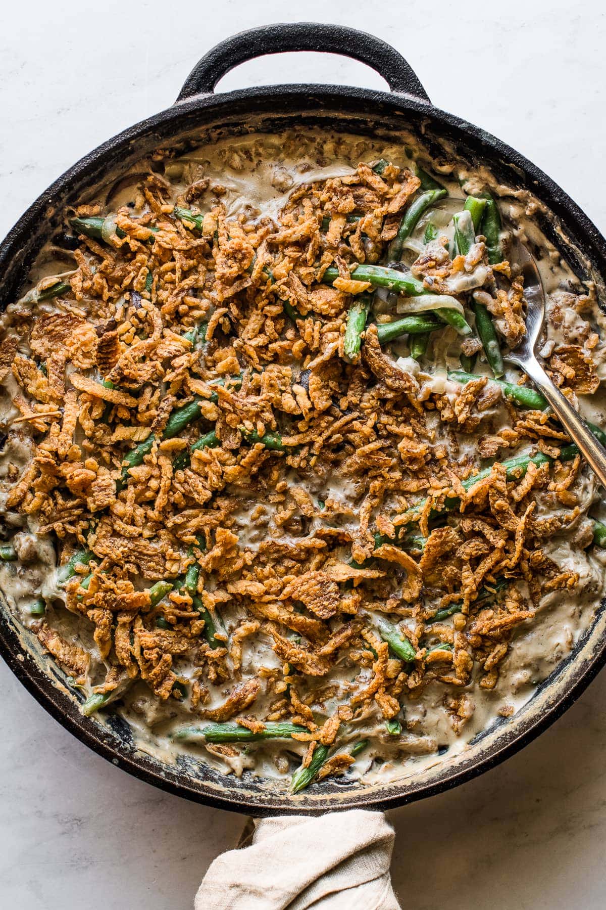 Green bean casserole recipe in a large skillet ready to serve.