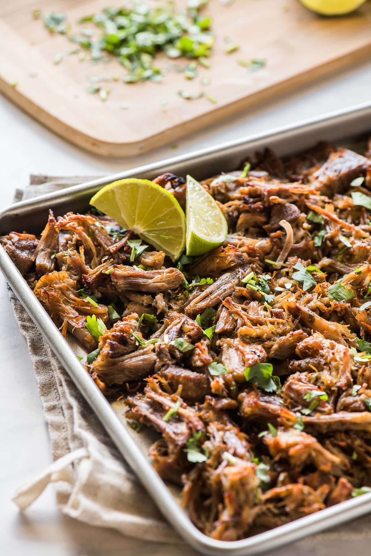 Crispy pressure cooker carnitas topped with cilantro on a baking sheet.