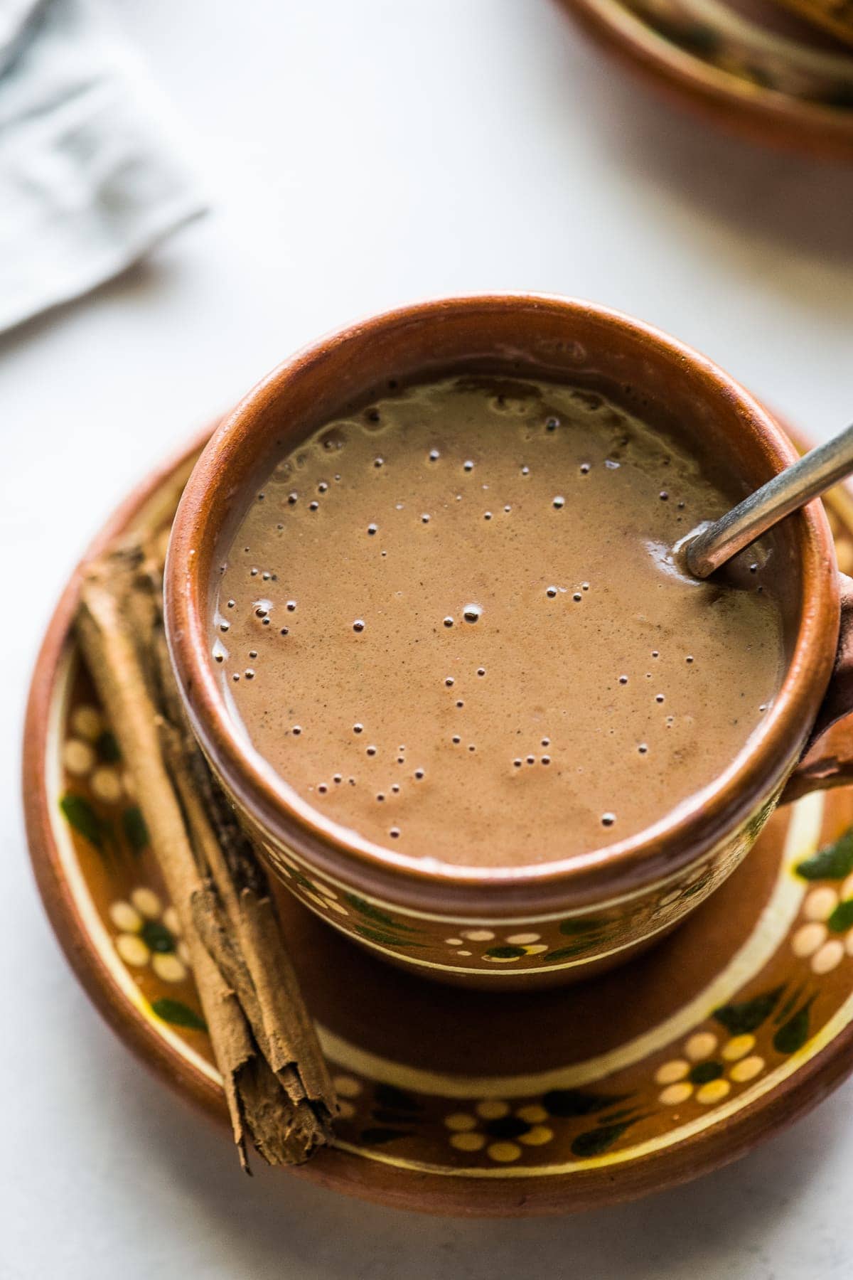 A thick and creamy champurrado in a Mexican mug.