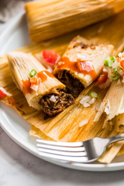 An Instant Pot Pork Tamale cut in half to show the center.