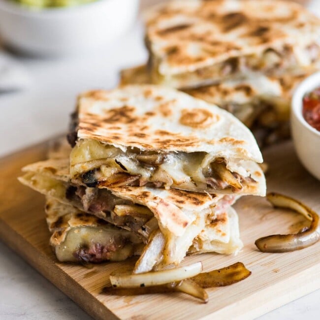 Steak quesadillas with melted cheese and sauteed onions.