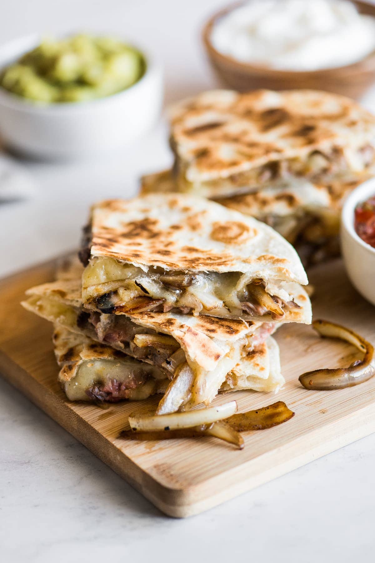 Steak quesadillas with melted cheese and sauteed onions.