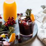 Winter sangria topped with cranberries, rosemary, and orange slices.