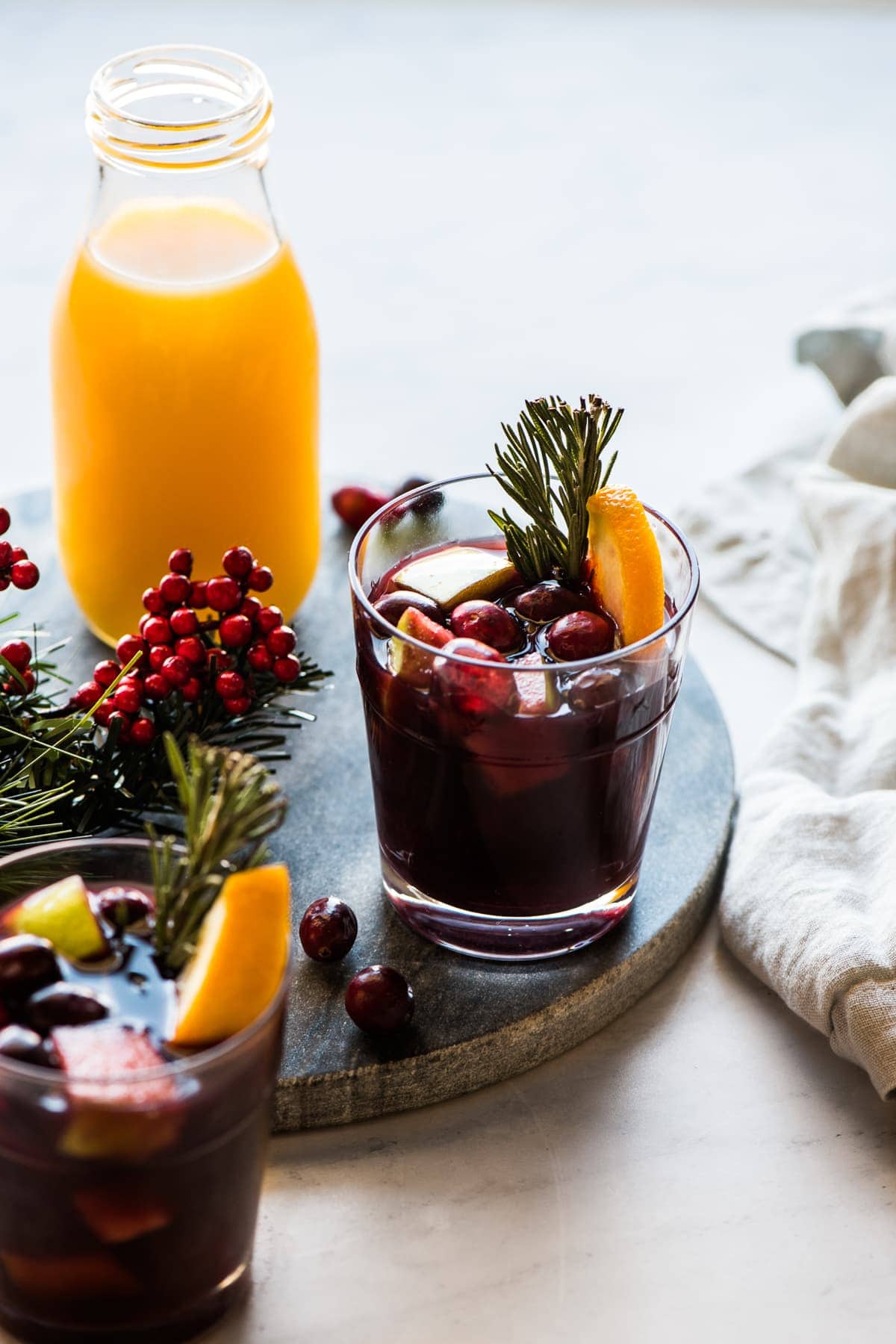 Winter sangria topped with cranberries, rosemary, and orange slices.