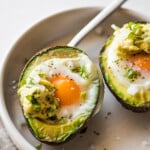 Avocado Egg Bake in a bowl seasoned with salt and pepper.