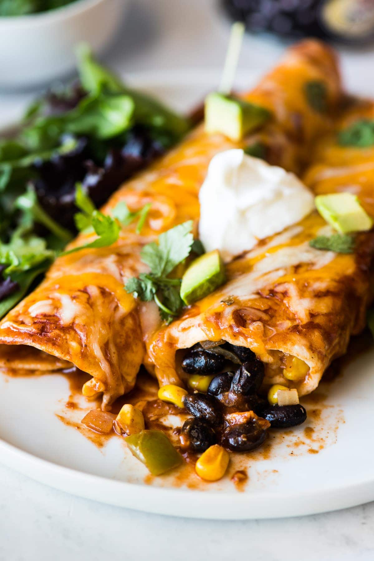 Black bean enchiladas topped with sour cream and cilantro.