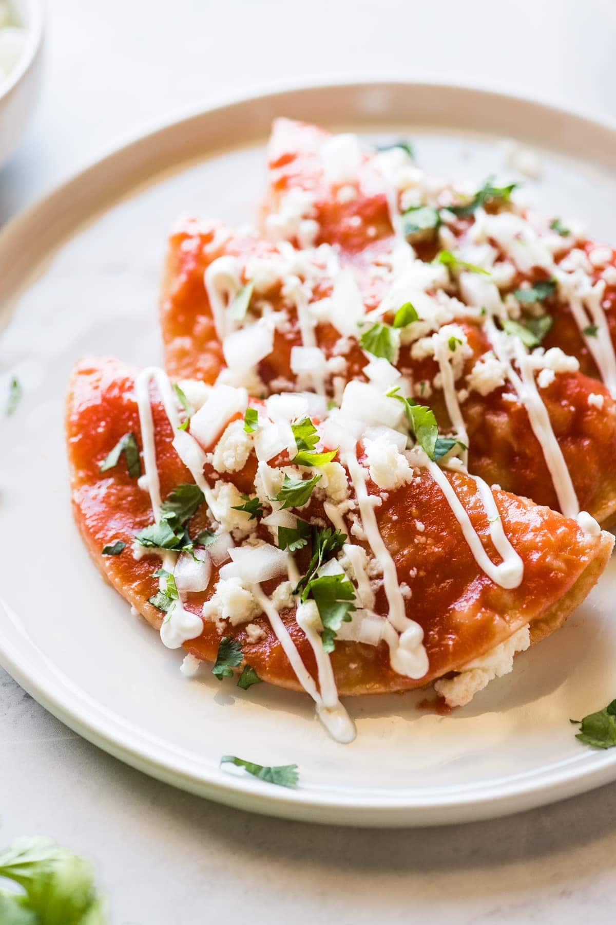 Entomatadas topped with queso fresco and Mexican crema.