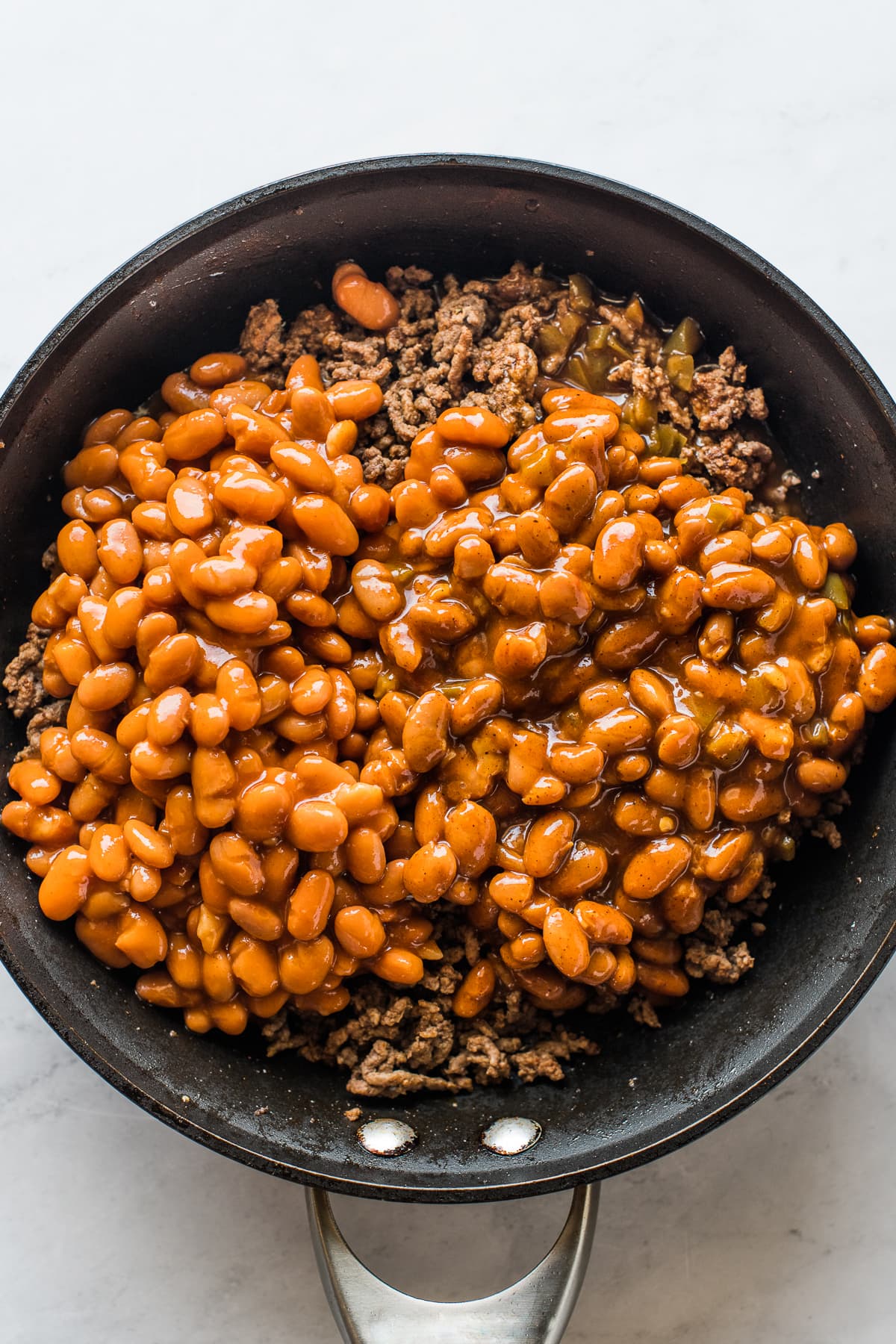 A skillet of beans and ground beef for walking tacos.